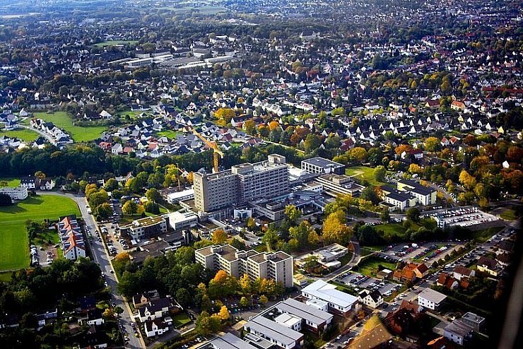 Die Blätter der Bäume haben sich herbstlich gelb verfärbt, der Kran hilft bei der Erweiterung des Klinikums.