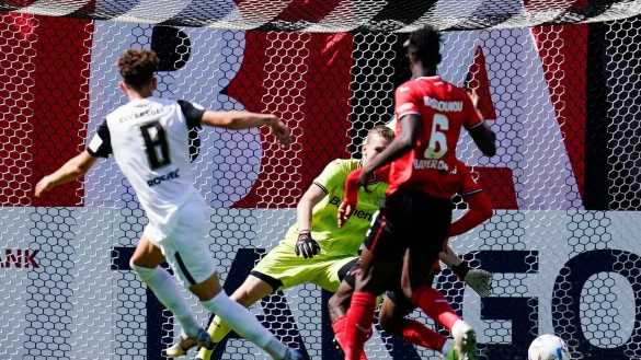 Elversbergs Jannick Rochelt (l) trifft an Leverkusens Torwart Lukas Hradecky vorbei zum 1:0. - &copy; Uwe Anspach/dpa