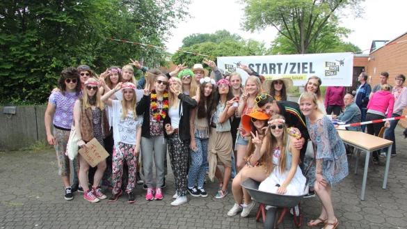Gut gelaunt: F&uuml;rs Pressefoto machen die Teilnehmer des Sponsorenlaufs eine kleine Pause. Der Platz in der Schubkarre bleibt w&auml;hrend der Runden um die Turnhalle nie frei. - &copy; Stefan Backe