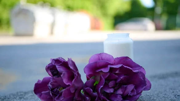 Blumen und eine Kerze liegen auf einem Schotterplatz vor dem Eingang zum Spielplatz, auf dem in der Nacht ein 17-J&auml;hriger einen 14-J&auml;hrigen erstochen haben soll. - &copy; Bernd Thissen/dpa