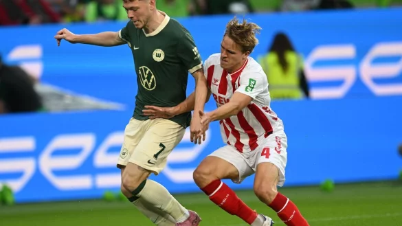 Im Zweikampf: Wolfsburgs Andreas Skov Olsen (l) und der Kölner Timo Hübers. - © dpa