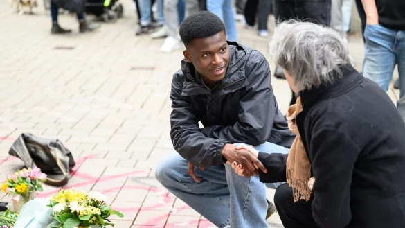 Suraj Mailitafi (l) von der Initiative &laquo;Gerechtigkeit f&uuml;r Lorenz&raquo; spricht mit einer Passantin an dem Ort, an dem der 21-J&auml;hrige von der Polizei erschossen wurde. - &copy; Izabela Mittwollen/dpa