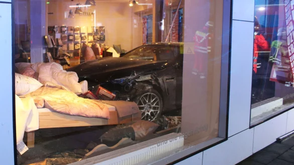Ein Auto landet bei einem Unfall in Minden im Bettengeschäft. - © -/Polizei Minden-Lübbecke/dpa