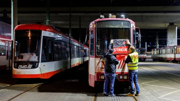 «Heute Streik» steht auf dem Plakat, dass Beschäftigte in Duisburg am frühen Morgen an eine Straßenbahn hängen. - © Christoph Reichwein/dpa