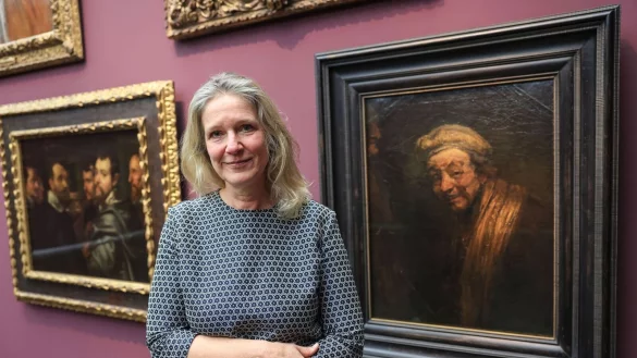 Anja Sevcik steht zwischen einem Selbstbildnis von Peter Paul Rubens unter Freunden (links) und einem Selbstbildnis von Rembrandt (rechts). - © Oliver Berg/dpa