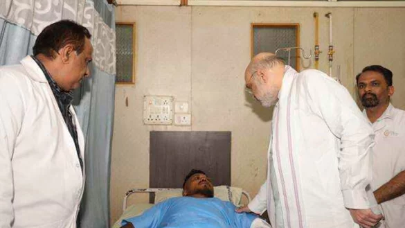 Das vom indischen Innenministerium herausgegebene Foto zeigt Innenminister Amit Shah bei einem Treffen mit dem Überlebenden des britischen Flugzeugabsturzes, Vishwash Kumar Ramesh, in einem Krankenhaus in Ahmedabad. - © Indian Ministry of Home Affairs/dpa