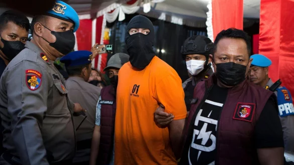 Die Angeklagten wurden in Sträflingsanzug und Sturmhaube der Presse vorgeführt. - © Firdia Lisnawati/AP/dpa