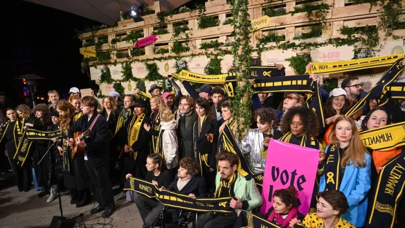 Mit Schals und Schildern haben Prominente an einer Protestaktion von SOS Humanity teilgenommen. - &copy; Christophe Gateau/dpa