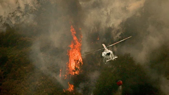 Ein Löschhubschrauber wirft Wasser über einem Feuer in der spanischen Provinz Ourense ab. - © Adrián Irago/EUROPA PRESS/dpa