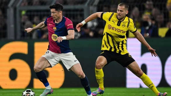 Barcelonas Robert Lewandowski (l) und Dortmunds Waldemar Anton kämpfen um den Ball. - © Federico Gambarini/dpa