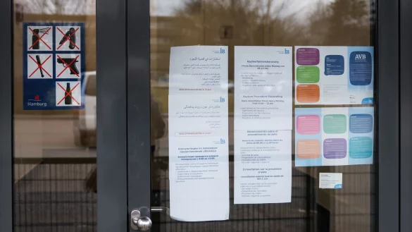 Am Eingang des Dublin-Zentrums in Hamburg-Rahlstedt hängen Informationsblätter, unter anderem zu den Sprechstunden der kostenlosen Asylverfahrensberatung. zu sehen. Die sogenannten Dublin-Regeln legen fest, in welchem europäischen Land ein Asylbewerber seinen Antrag auf Schutz stellen darf. (Archivfoto) - © Christian Charisius/dpa POOL/dpa