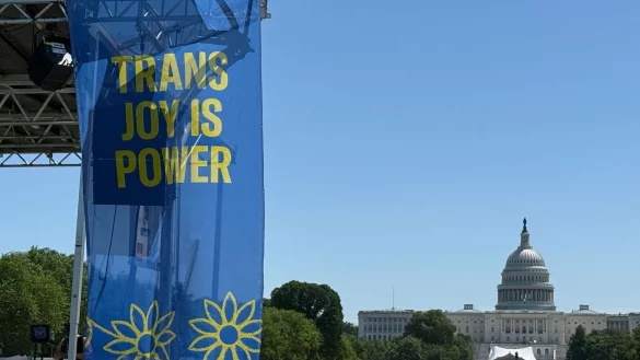 „Trans joy is power“ steht auf einem Banner an einer Bühne vor dem Kapitol am ersten Tag der Worldpride. - © Franziska Spiecker/dpa