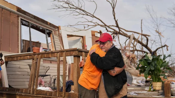 Nach dem Durchzug eines Tornados in Missouri spenden sich Freunde Trost und räumen auf. - © Jeff Roberson/AP/dpa