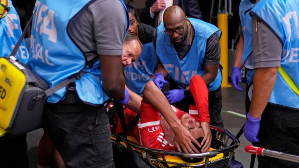 Jamal Musiala liegt verletzt auf einer Trage. - © Brynn Anderson/AP/dpa