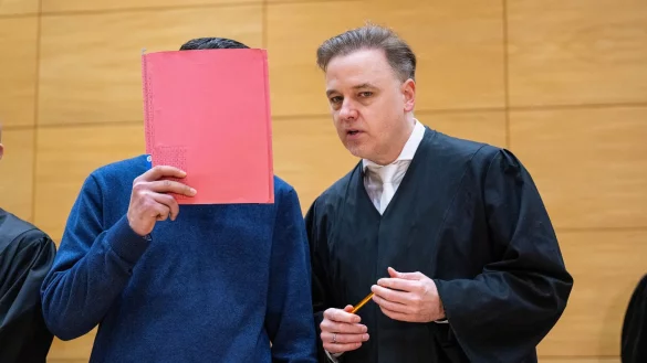 Einer der Angeklagten (links) steht mit seinem Anwalt Burkhard Benecken beim Beginn des Prozesses um den Totschlag nach einer Abifeier in Bad Oeynhausen an der Anklagebank. (Archivfoto) - © Guido Kirchner/dpa