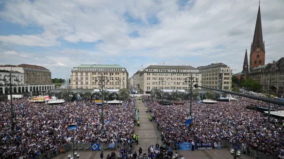 HSV-Fans stehen auf dem Rathausmarkt vor dem Hamburger Rathaus und feiern ihren Club. - © Christian Charisius/dpa