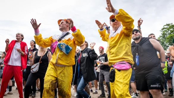 Nach dem vielen Regen tanzten viele Fans im Matsch. - © Daniel Karmann/dpa