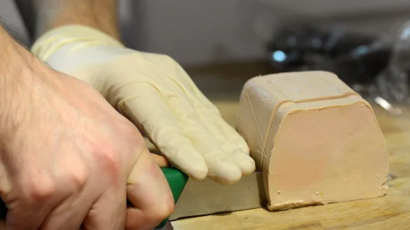 Ein Metzger schneidet eine Scheibe französische Gänsestopfleber. (Archivbild) - © picture alliance / dpa