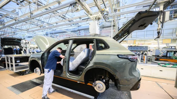 Mitarbeiter montieren in Wolfsburg den VW Tayron. (Archivbild) - © Julian Stratenschulte/dpa