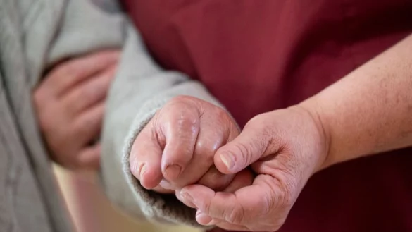 Eine Pflegekraft betreut in einem Seniorenhaus einen Bewohner. - &copy; Marijan Murat/dpa