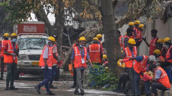 Arbeiter sind an der Absturzstelle im Einsatz. - © Rafiq Maqbool/AP/dpa