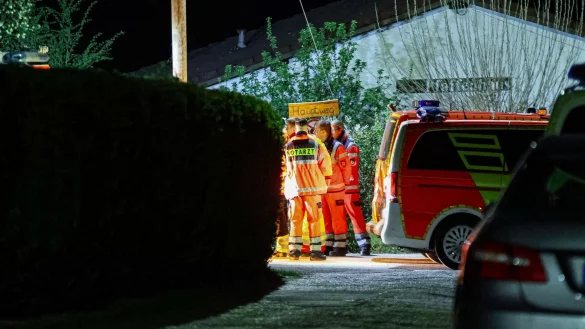 Helfer und ein Notarzt stehen in einer Kleingartenanlage in Wuppertal. Sie können nicht mehr helfen. - © Florian Schmidt/dpa