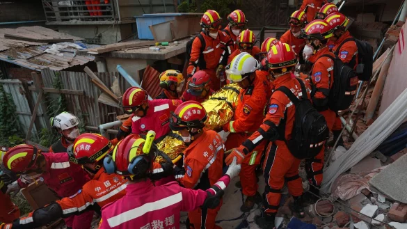 Rettungskr&auml;fte befreien einen &Uuml;berlebenden unter Tr&uuml;mmern. - &copy; Cai Yang/XinHua/dpa