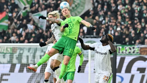 Wolfsburgs Patrick Wimmer (M) und Leverkusens Robert Andrich (l) im Kopfballduell. - © Swen Pförtner/dpa