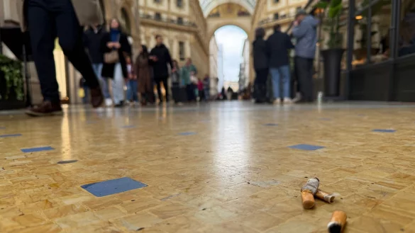 In der Viktor-Emanuel-II.-Galerie, der Einkaufspassage Galleria Vittorio Emanuele II, liegen Zigarettenkippen auf dem Boden. - © Christoph Sator/dpa