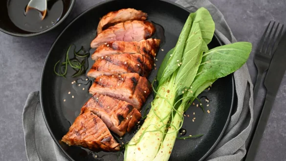 Hoisin-Sauce gibt dem Schweinefilet Würze und eine Karamellnote. Dazu wird Pak Choi serviert. - © Julia Uehren/loeffelgenuss.de/dpa-tmn