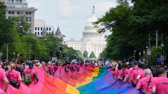 Mit riesigen Regenbogenfahnen demonstrieren Menschen mit Blick auf das US-Kapitol bei einer Pride-Parade in Washington für die Rechte der LGBTQI+-Gemeinschaft. - © Mark Schiefelbein/AP/dpa