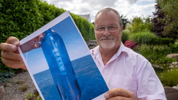 Jörg Wanke zeigt ein Foto seiner Flaschenpost. - © Stefan Sauer/dpa