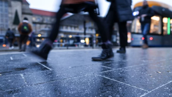 Glatteis erhöht das Sturzrisiko erheblich. Doch mit ein paar Tricks kommt man sicher an. - © Jan Woitas/dpa