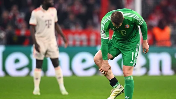 Manuel Neuer fasst sich an die verletzte Wade. - © Tom Weller/dpa