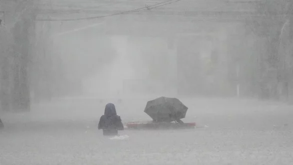 Die Menschen mussten durch brusttiefes Wasser waten. - &copy; Aaron Favila/AP/dpa