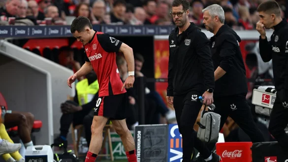 Bayer Leverkusens Mittelfeldstar Florian Wirtz humpelt verletzt vom Platz. - © Federico Gambarini/dpa