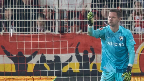 Bochums Keeper Patrick Drewes hält das Feuerzeug hoch, das ihn getroffen hat. - © Andreas Gora/dpa