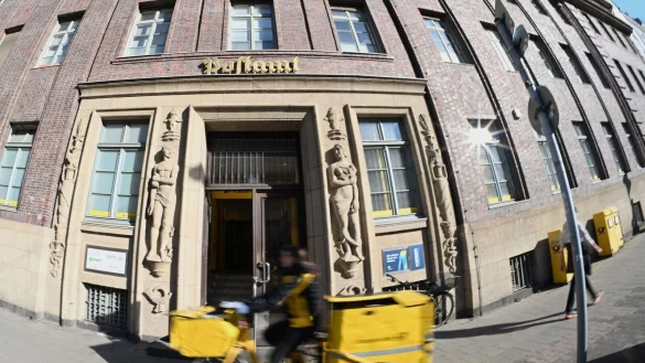 Eine Brieftr&auml;gerin f&auml;hrt an einer Postfiliale vorbei - vielleicht ist auch sie eine Beamtin? - &copy; Wolf von Dewitz/dpa