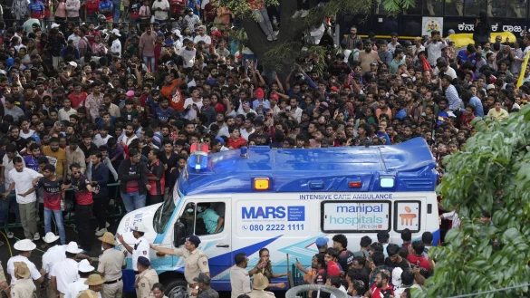 Ein Krankenwagen bahnt sich den Weg durch eine Menschenmenge am M. Chinnaswamy-Stadion in der indischen Stadt Bengaluru. - © Aijaz Rahi/AP/dpa