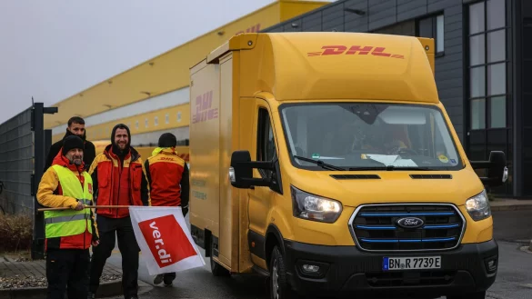 Post-Mitarbeiter am Werkstor, aber nicht auf dem Werktor. Der Grund: Sie sind im Warnstreik. - © Oliver Berg/dpa