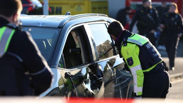 Einsatzkräfte untersuchen nach dem Unfall ein Fahrzeug. - © Gianni Gattus/dpa