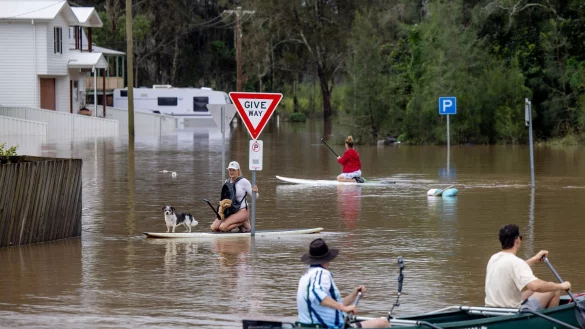Viele Menschen konnten sich nur noch mit Booten und Paddleboards fortbewegen. - © Lindsay Moller/AAP/dpa