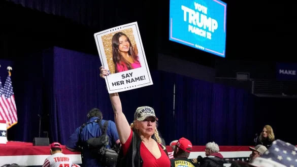 Eine Trump-Unterstützerin hält bei einer Wahlkampfveranstaltung im Bundesstaate Georgia ein Schild in die Höhe, dass die ermordete Studentin Laken Riley zeigt. (Archivbild) - © Mike Stewart/AP
