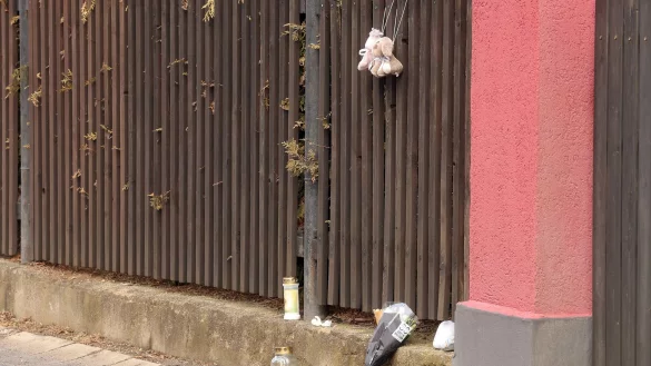 Blumen, Kerzen und Plüschtiere sind an einem Gartenzaun in Neumark niedergelegt. Im Ortsteil soll ein Vater erst seine beiden Kinder, dann sich selbst getötet haben. - © Bodo Schackow/dpa