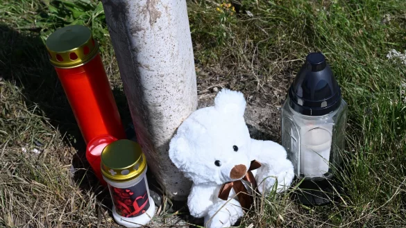 Menschen haben Kerzen und einen Teddybären an der Unfallstelle abgestellt. - © Bernd Weißbrod/dpa