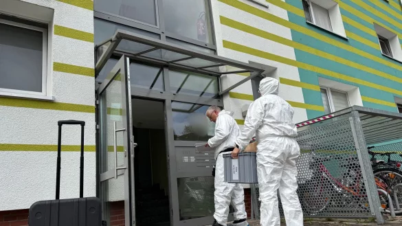 Einsatzkräfte untersuchen den Tatort, an dem eine 43-Jährige erstochen wurde. - © Christian Müller/dpa