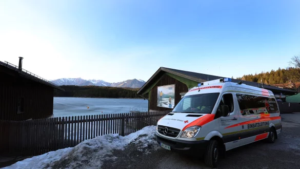 Ein Einsatzfahrzeug des Roten Kreuzes steht am Ufer des Eibsees, nahe der Stelle an der am Nachmittag mehrere Menschen im Eis eingebrochen waren. - © Karl-Josef Hildenbrand/dpa