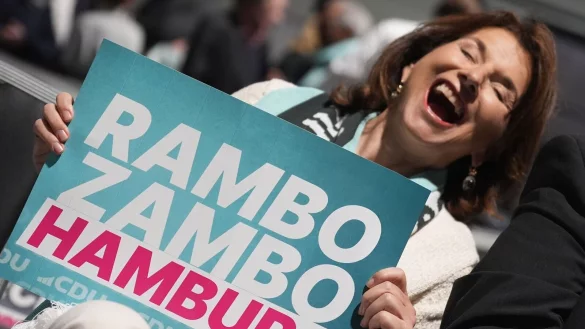 Die Unternehmerin und Reality-TV-Darstellerin Claudia Obert hält ein «Rambo Zambo»-Schild: Die Formel «Rambo Zambo» hatte Merz im Wahlkampffinale mehrmals aufgegriffen. (Archivbild) - © Marcus Brandt/dpa