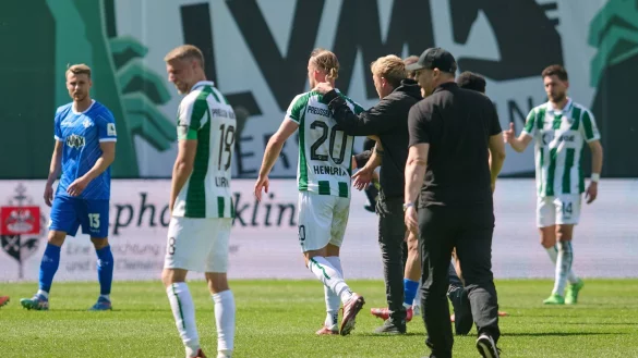 Münsters Trainer Sascha Hildmann geht nach dem Spiel über den Rasen. - © Bernd Thissen/dpa