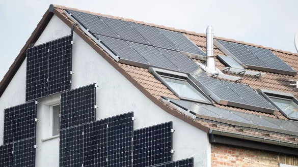 Solarpanel sind an der Fassade und auf dem Dach eines Hauses befestigt. - © Sebastian Gollnow/dpa